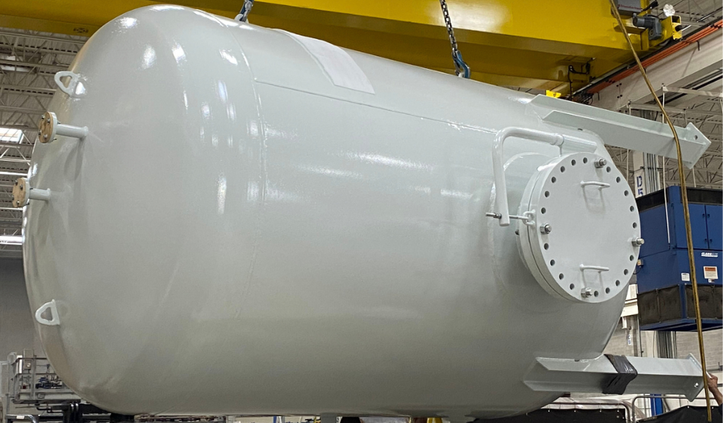 Untitled design (2) Side view of a custom carbon steel buffer vessel showing its circular access cover and nozzle connections